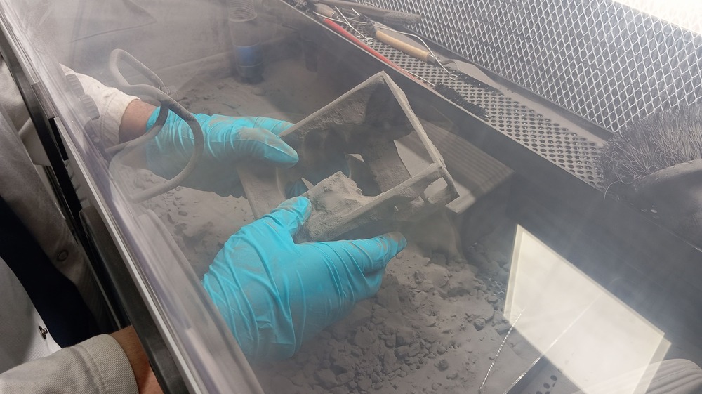 Extraction d’une pièce imprimée en 3D SLS du lit de poudre